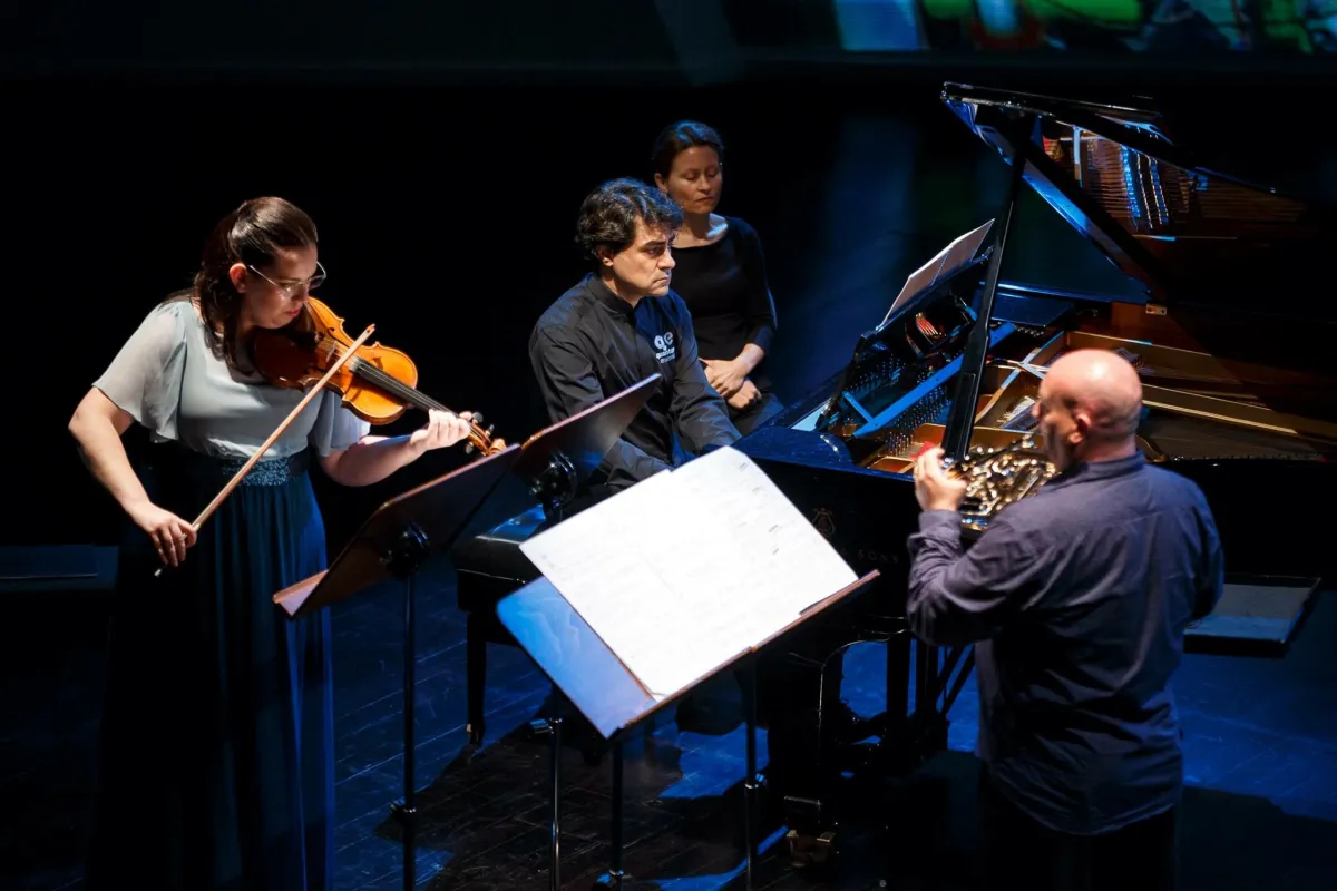 Oscar Sala interpretando el Trío de Brahms con violín y piano en un escenario